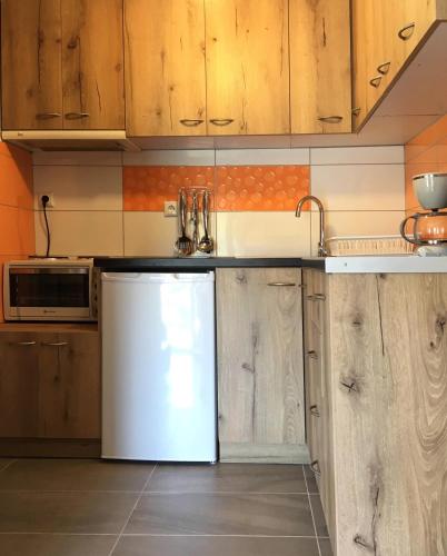 a kitchen with wooden cabinets and a refrigerator at White House in Lákka