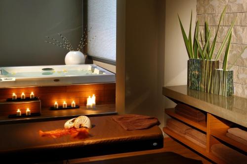 a bath room with a tub and a table with candles at Cavo Olympo Luxury Hotel & Spa - Adult Only in Plaka Litochorou