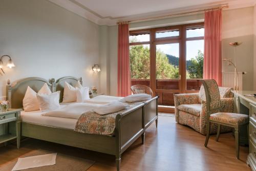 a bedroom with a bed and a large window at Landhaus Sonnenhof in Adenau