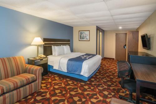 a hotel room with a bed and a couch at Days Inn By Wyndham Carlisle North in Carlisle