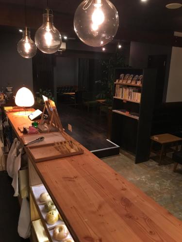 un lungo bancone in legno in una stanza con luci di Hokkaido Bed & Bagel a Eniwa