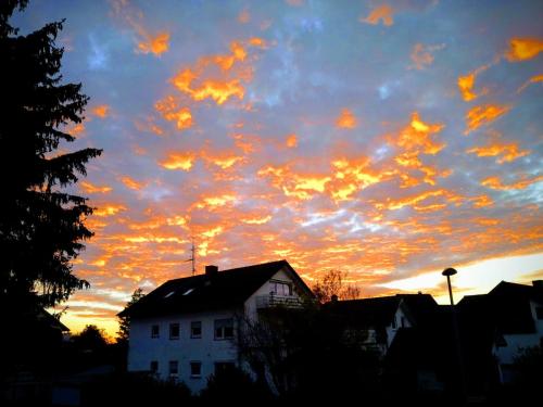 a cloudy sky at sunset with a house in the foreground at Familiehuis Dolve 2 in Hartheim