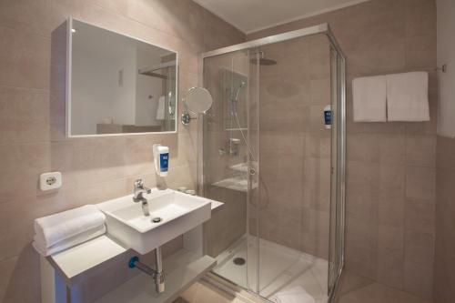 y baño con lavabo y ducha. en Grupotel Rocador - Adults Only en Cala D'Or