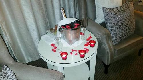 a table with a bucket and glasses on it at Classique Grace Boutique Hotel in Johannesburg