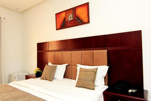 a bedroom with a large bed with a wooden headboard at Les Residences MAMOUNE in Dakar