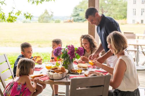 a family sitting around a table eating food at Domaine De La Boulaie in Treize-Vents
