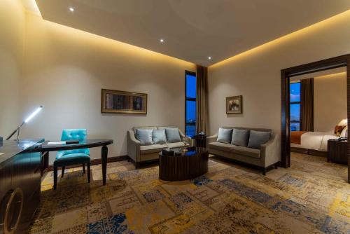 a living room with a desk and a couch at Warwick Al Khobar in Al Khobar