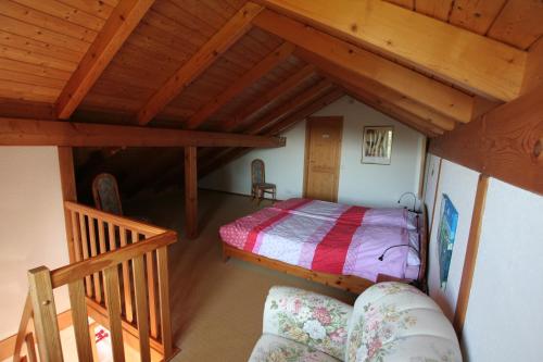 um quarto no sótão com uma cama e uma escada em Fewo to Hus em Bad Bederkesa