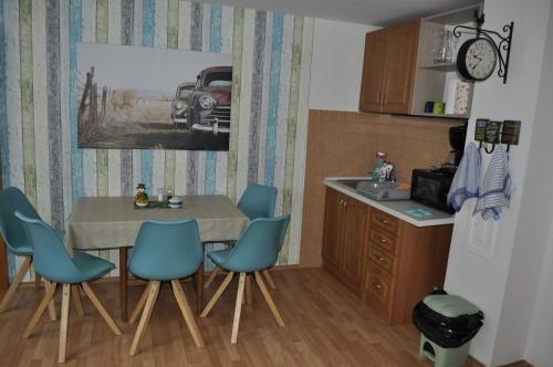 a kitchen with a table and chairs and a refrigerator at Apartmány CENTRUM in Rajecké Teplice