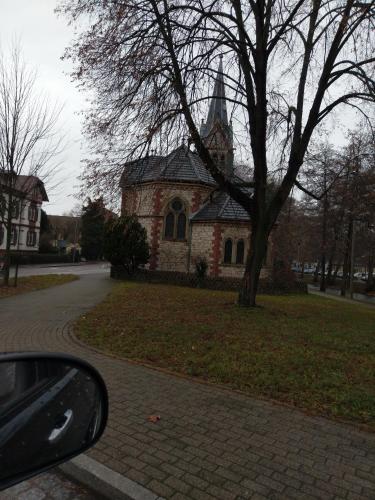 a brick church with a clock tower and a car at Familiehuis Dolve 2 in Hartheim