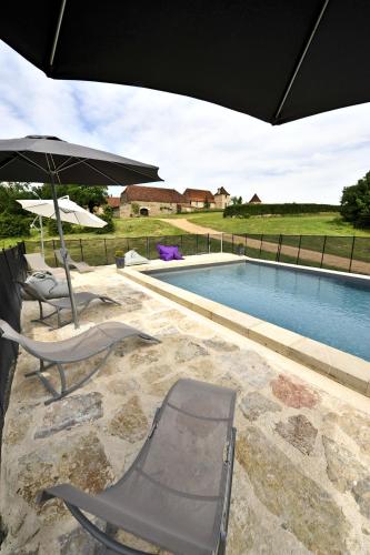 deux chaises et un parasol à côté d'une piscine dans l'établissement Gîte 8 pers du Château de Cantecor, à Alvignac