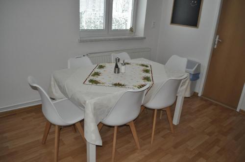 a white table with white chairs and a white table cloth at Apartmány CENTRUM in Rajecké Teplice