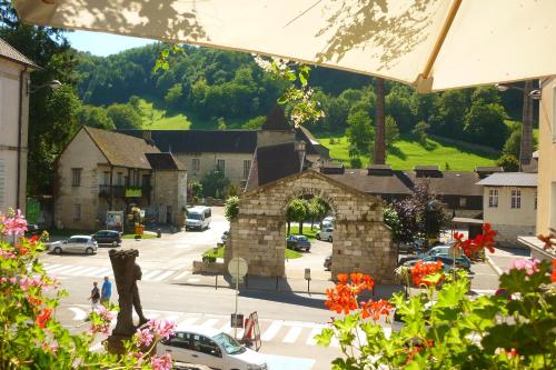 a view of a town with a stone arch in a street at Logis Hôtel des Deux Forts in Salins-les-Bains