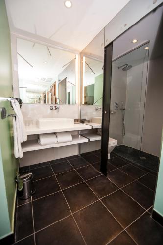 a bathroom with a large mirror and a sink at Posada del León de Oro Boutique Hotel in Madrid