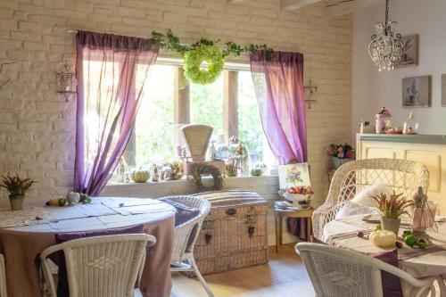 a dining room with tables and chairs and a window at Le Bonheur à la Campagne in Lesmont