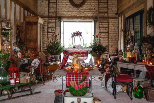 a room with christmas trees and a table in a room at Le Bonheur à la Campagne in Lesmont