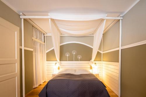 a bedroom with a bed with a canopy at Kinderhotel Appelhof in Mürzsteg