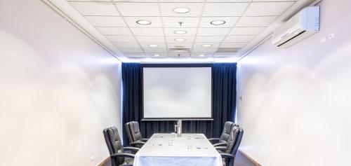 a conference room with a table and chairs and a screen at The Lord Forrest Hotel in Bunbury