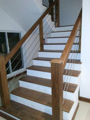 a staircase with wooden railings and white stairs in a house at Bayfront in Weligama