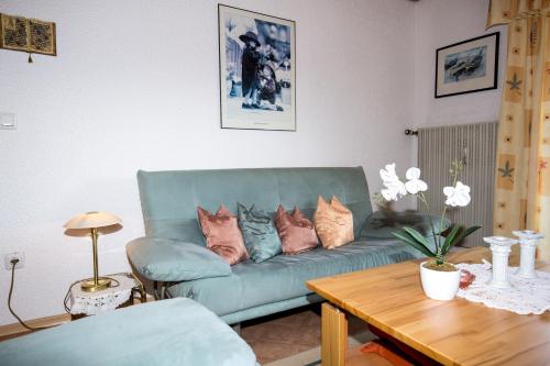 a living room with a blue couch with pillows on it at Haus Osserblick in Arrach