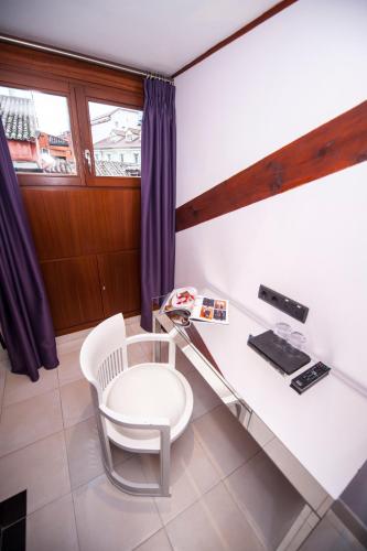 a desk with a white chair and a glass table at Posada del León de Oro Boutique Hotel in Madrid