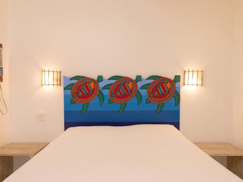 a bedroom with a bed with a blue and red headboard at Pousada Perequê in Ilhabela