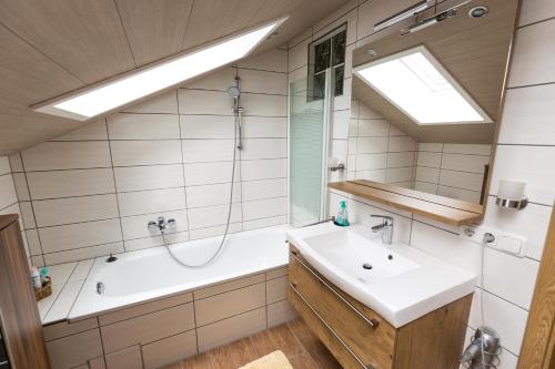 a bathroom with a tub and a sink and a shower at Haus Osserblick in Arrach