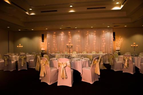 a room with white tables and chairs with white bows at The Lord Forrest Hotel in Bunbury