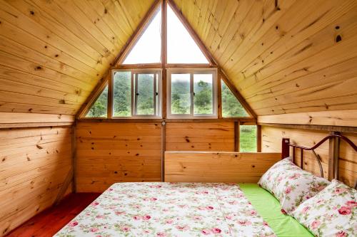 a bedroom with a bed in a wooden cabin at Pousada Pico da Galera/Maquiné in Barra do Ouro