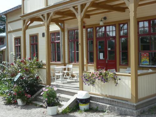 a small house with a porch and some flowers at Ronneby Brunnspark Vandrarhem och B&B in Ronneby