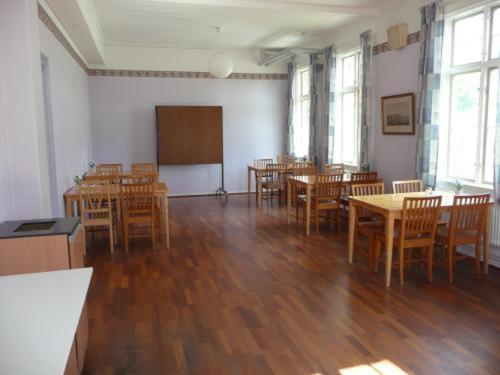 a classroom with wooden tables and chairs and a chalkboard at Ronneby Brunnspark Vandrarhem och B&B in Ronneby