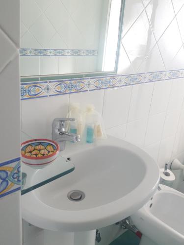 un bagno bianco con lavandino e specchio di Villa Casola B&B a Positano