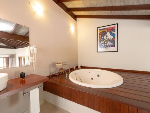 a large bathroom with a tub and a sink at Pousada Perequê in Ilhabela