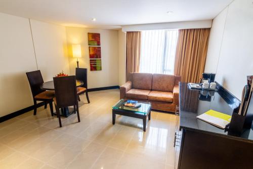 a living room with a couch and a table at Sonesta Hotel Cali in Cali
