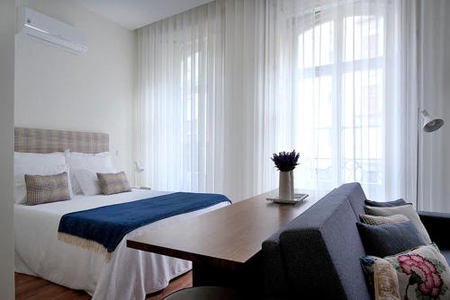1 dormitorio con cama, mesa y sofá en Mayor's Apartments, en Oporto