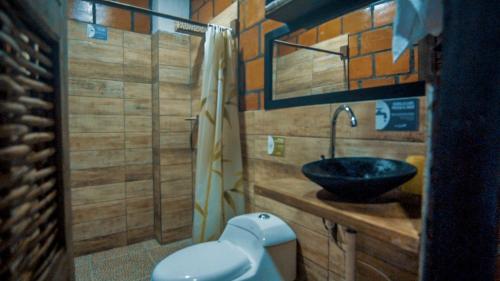 a bathroom with a sink and a toilet at Hotel Acuali Nuqui in Nuquí