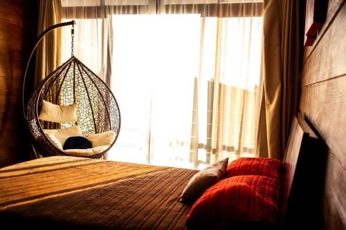 a bedroom with a bed with a swing and a window at Espectacular casa de montaña con jacuzzi, chimenea a leña y BBQ in Zarcero