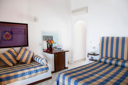 a hotel room with two beds and a television at Hotel Cincotta in Panarea