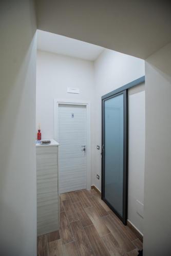 a room with white walls and a door and wooden floors at Bellorizzonte in Naples