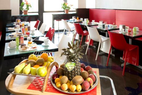a tray of fruit on a table in a restaurant at Hotel Milano Navigli in Milan