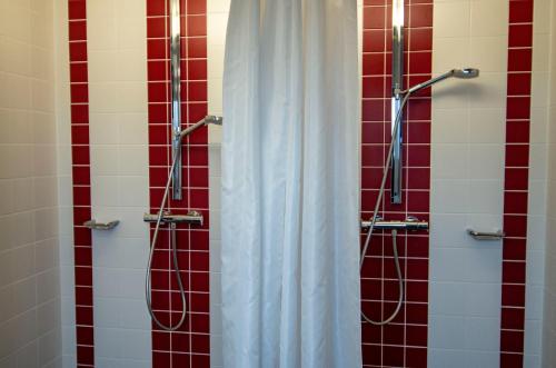 a shower with red and white tiles in a bathroom at Ausbildungshotel St. Theresia in Munich