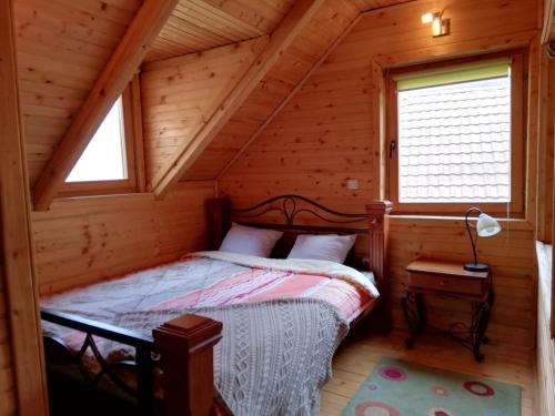 ein Schlafzimmer mit einem Bett in einem Blockhaus in der Unterkunft Vikendice Biocinovici in Kolašin