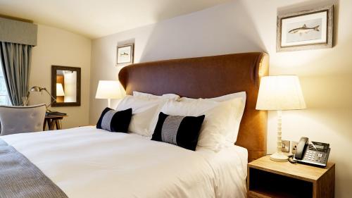 a bedroom with a large bed with a phone on a table at The Wellington Arms - Basingstoke-Reading in Heckfield