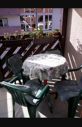 einen Tisch und Stühle auf einem Balkon mit Tisch und Stühlen in der Unterkunft Apartman S in Palisat