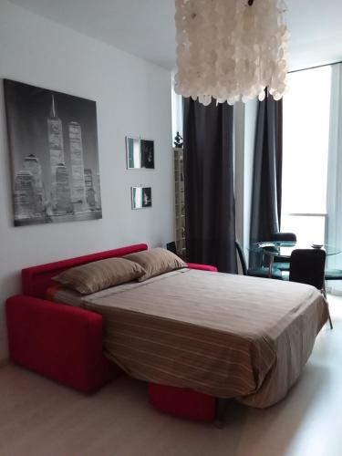 a bedroom with a bed and a red couch at baricarulli52 in Bari
