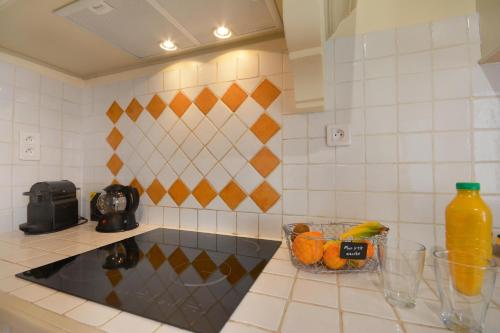 a kitchen counter with a bowl of fruit and a sink at Mas et Gite de la Picholine in LʼIsle-sur-la-Sorgue