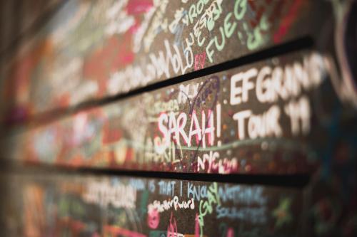 a wall covered in graffiti with writing on it at room00 Ventura Hostel in Madrid