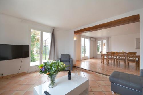 a living room with a vase of flowers on a table at Mas et Gite de la Picholine in LʼIsle-sur-la-Sorgue