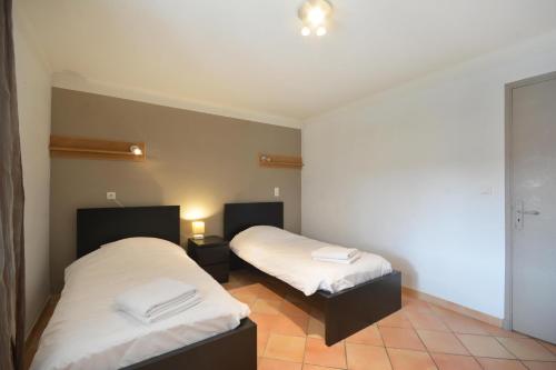a room with two beds with white sheets at Mas et Gite de la Picholine in LʼIsle-sur-la-Sorgue