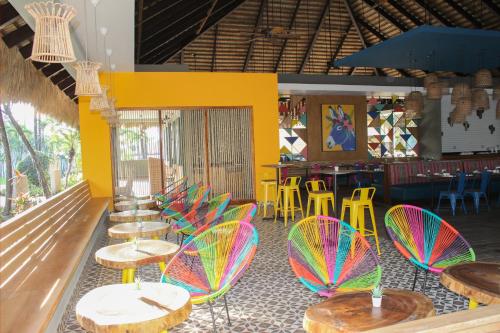 a restaurant with colorful chairs and tables and a bar at Casa Marina Beach & Reef All Inclusive in Sosúa